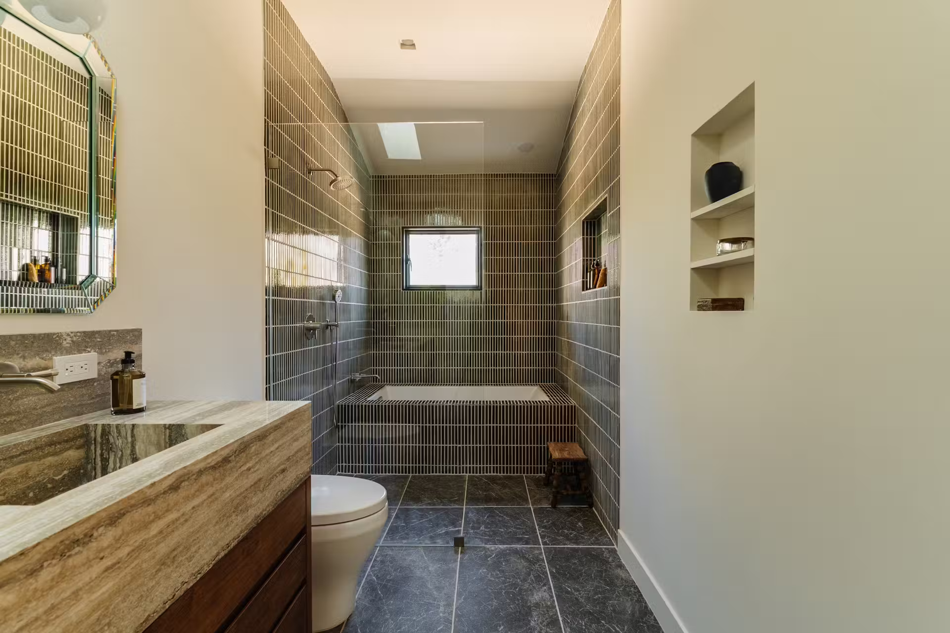 Modern prefab home with dark cladding set in a landscaped yard